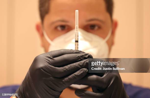 Jatniel Hernandez fills syringes with COID-19 vaccine booster shots at a COVID-19 vaccination clinic on April 06, 2022 in San Rafael, California. The...