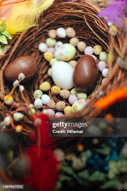 chocolate easter eggs in an easter basket - easter basket with candy stock pictures, royalty-free photos & images