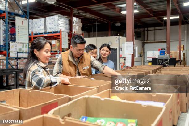 packing at a local food bank - banco alimentar imagens e fotografias de stock