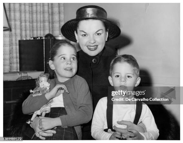Actress Judy Garland holds her children Lorna Luft and Joey Luft aboard a ship on a trip to Europe in a candid shot taken in 1957, United States.
