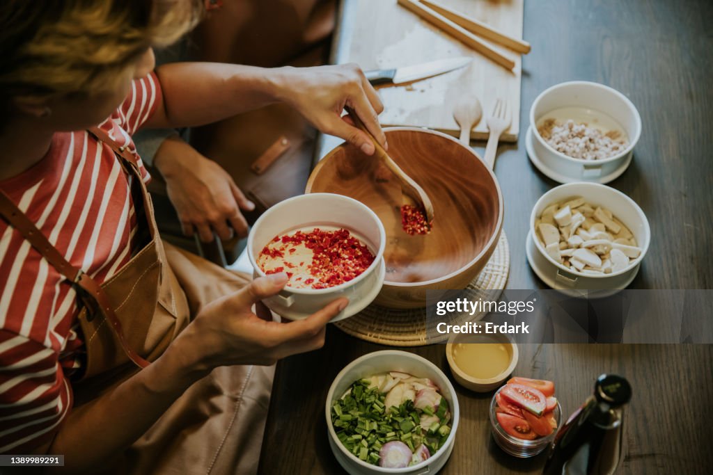 Weekend activity of asian gay couple cooking Thai salad for lunch together.