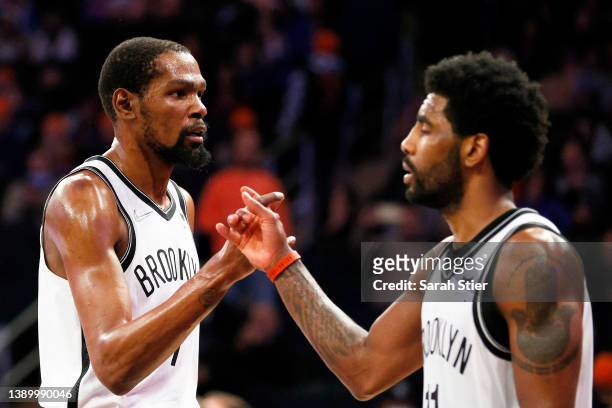 Kevin Durant and Kyrie Irving of the Brooklyn Nets react during the second half against the New York Knicks at Madison Square Garden on April 06,...