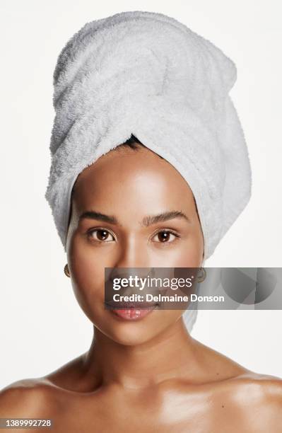 studio shot of an attractive young woman with a towel wrapped around her head against a white background - toalha imagens e fotografias de stock