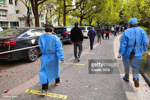 People maintain the social distance of two meters as they queue up for COVID-19 nucleic acid tests on April 6, 2022 in Shanghai, China.