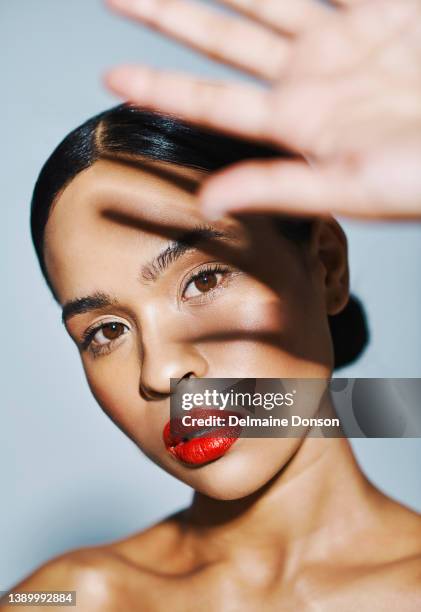 studio shot of an attractive young woman posing against grey background - menselijke lippen stockfoto's en -beelden