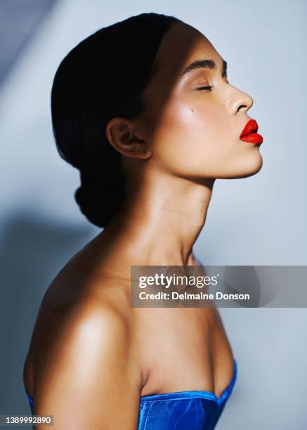 studio shot of an attractive young woman posing against grey background - red lips stock pictures, royalty-free photos & images