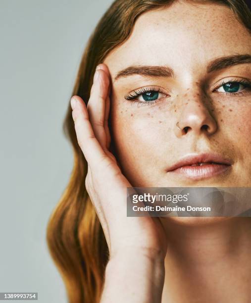 studioaufnahme einer attraktiven jungen frau, die vor grauem hintergrund posiert - beauty shot of young woman stock-fotos und bilder