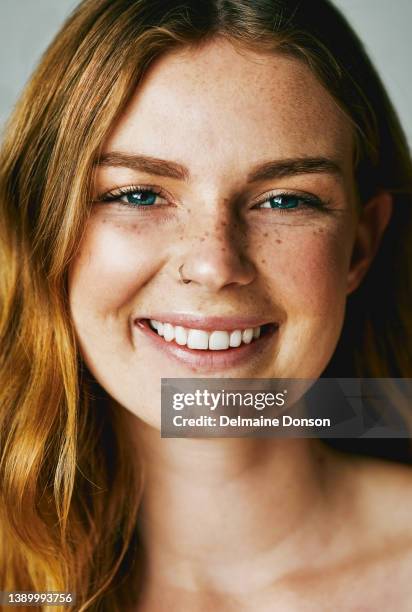 studio shot of an attractive young woman posing against grey background - freckle stock pictures, royalty-free photos & images