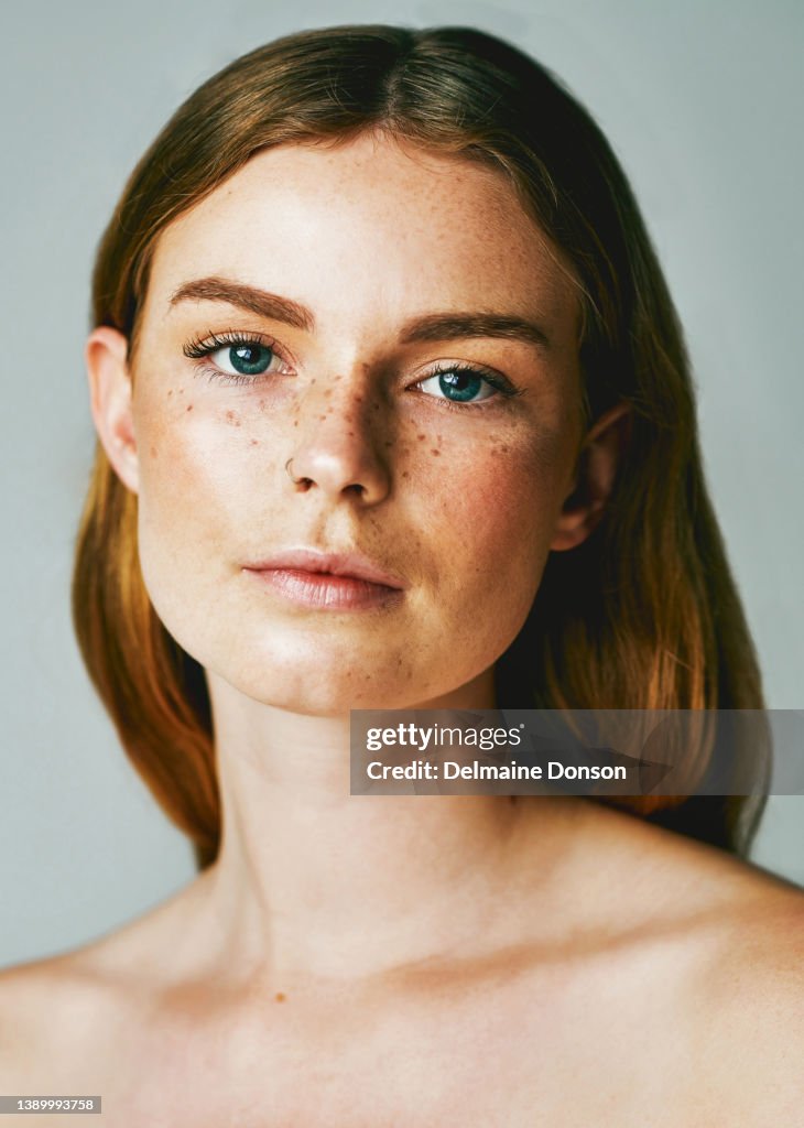 Studio shot of an attractive young woman posing against grey background