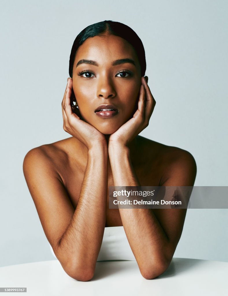 Studio shot of an attractive young woman posing against grey background
