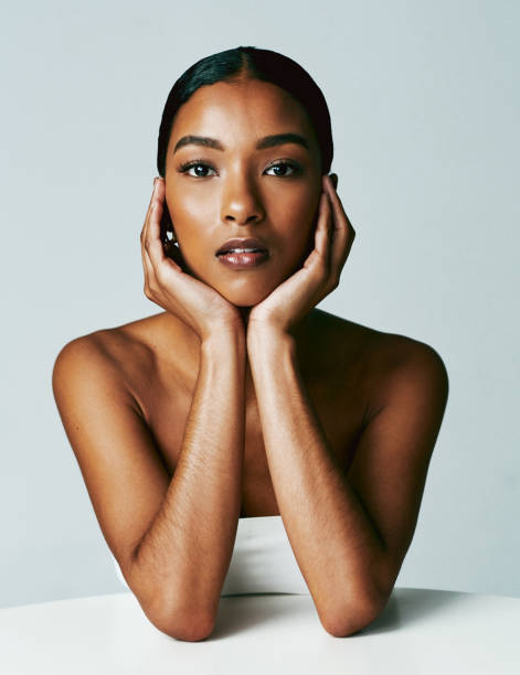 studio shot of an attractive young woman posing against grey background - mulher bonita imagens e fotografias de stock