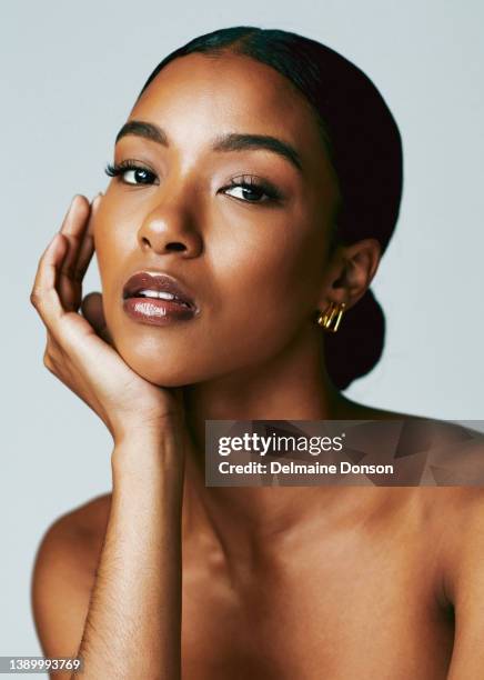 studio shot of an attractive young woman posing against grey background - schoonheidsbehandeling stockfoto's en -beelden