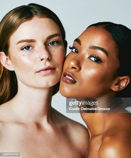 studio shot of two attractive young women posing against grey background - skin care model stock pictures, royalty-free photos & images