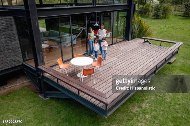 glückliche familie frühstückt im freien auf der terrasse - holzterrasse stock-fotos und bilder