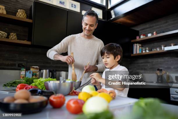 pai e logo cozinhando juntos na cozinha em casa - stay home - fotografias e filmes do acervo