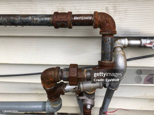 rusted gas pipe fittings outside house - broken pipe stockfoto's en -beelden