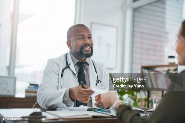 shot of a mature doctor having a consultation with his patient - exam papers stock pictures, royalty-free photos & images