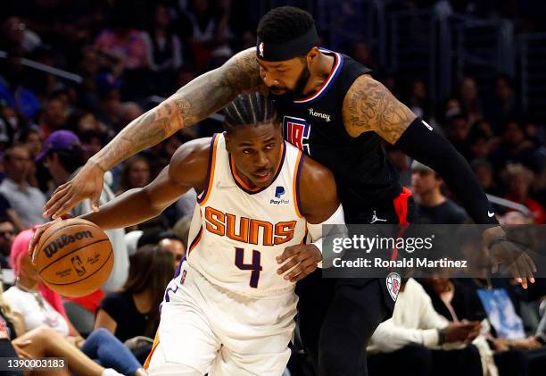 Aaron Holiday of the Phoenix Suns dribbles the ball against Marcus Morris Sr. #8 of the LA Clippers in the third quarter at Crypto.com Arena on April...
