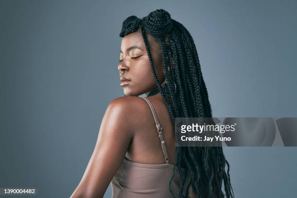 studioaufnahme einer trendigen jungen frau, die vor grauem hintergrund posiert - black woman hair stock-fotos und bilder