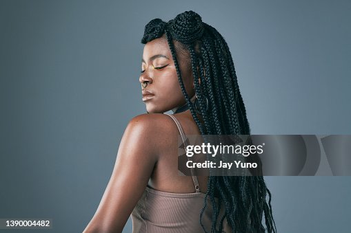 Studio shot of a trendy young woman posing against a grey background Studio shot of a trendy young woman posing against a grey background