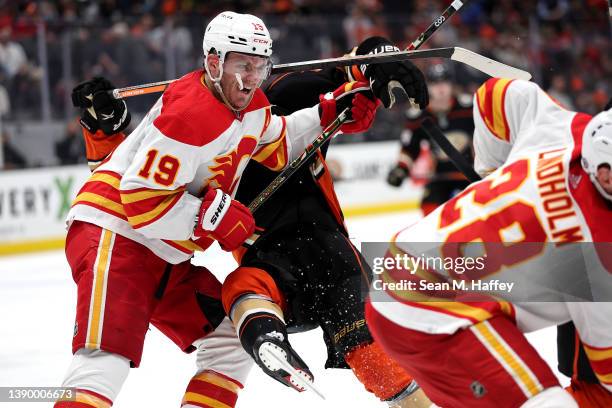 Matthew Tkachuk of the Calgary Flames checks Trevor Zegras of the Anaheim Ducks at the faceoff circle during the third period of a game at Honda...