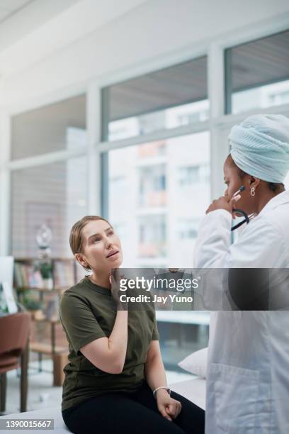shot of a doctor having a consultation with a young woman - human gland stockfoto's en -beelden