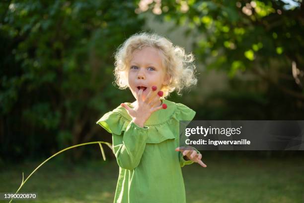 close-up of girl eating raspberries off fingers - 4 life natural foods stock-fotos und bilder