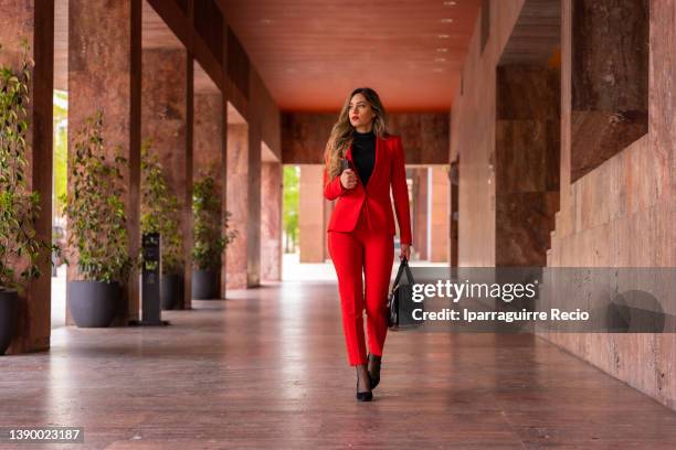 young caucasian businesswoman in a red suit arriving at a hotel, business trip - star style lounge imagens e fotografias de stock
