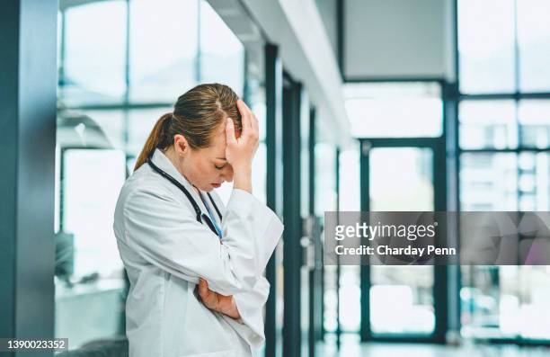 shot of a young doctor looking stressed in a modern hospital - shameful stock pictures, royalty-free photos & images