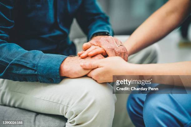 shot of an unrecognisable nurse holding hands with a senior patient - final imagens e fotografias de stock