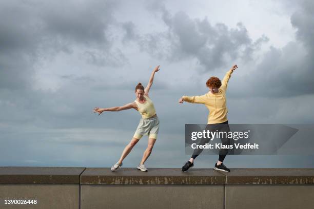 ballerina practicing with male dancer on wall - dance photos et images de collection