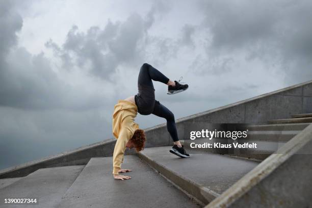 flexible male ballet dancer practicing on steps - urban ballet imagens e fotografias de stock