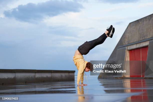 ballet dancer practicing handstand on footpath - best drama series stock-fotos und bilder