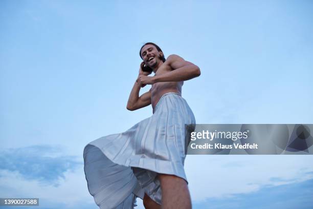 smiling ballet dancer in skirt standing against sky - skirt stock-fotos und bilder