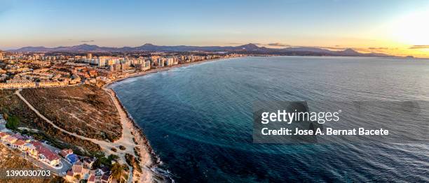 aerial view of a city by the sea at sunrise. - alicante street stock pictures, royalty-free photos & images