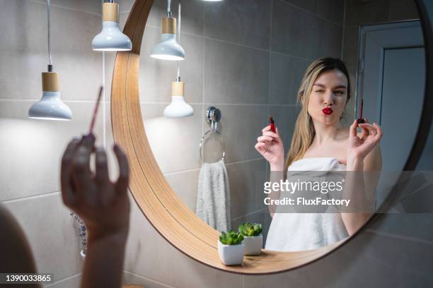 メイクをしながら鏡に映る若い女性 - puckering ストッ�クフォトと画像