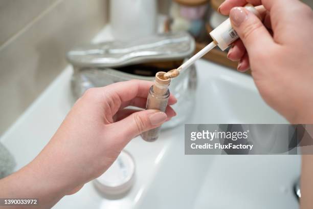 unrecognizable young woman holding the bottle of the face concealer - concealer stock pictures, royalty-free photos & images