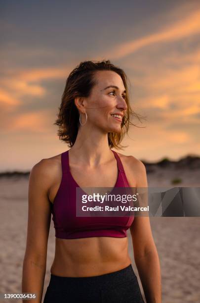 cheerful sportswoman standing near sea - bra stock pictures, royalty-free photos & images