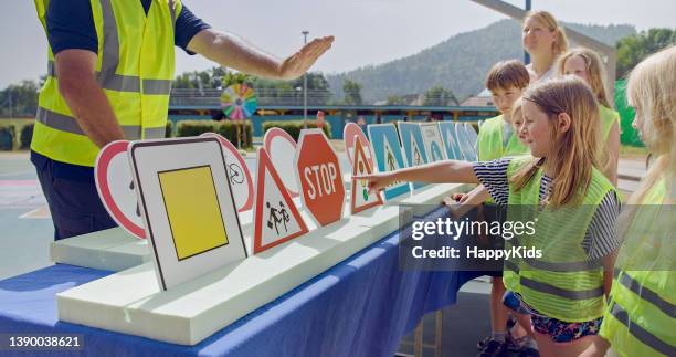 kinder, die auf verkehrsschilder schauen - regeln stock-fotos und bilder