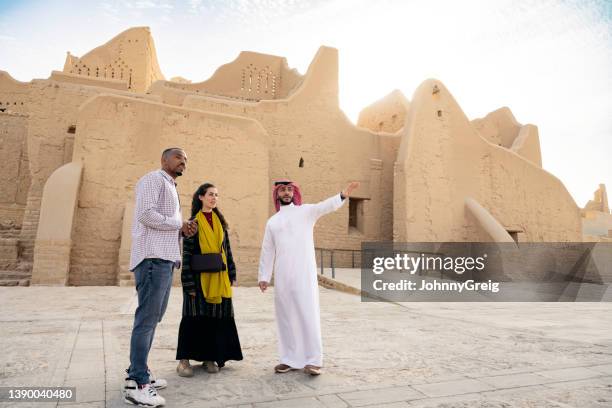 male saudi guide showing tourists ruins of at-turaif - saudi arabia national day stock pictures, royalty-free photos & images