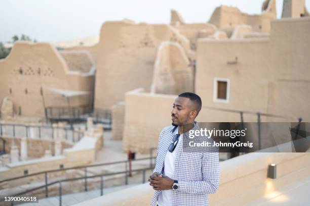 candid portrait of male tourist enjoying ruins of at-turaif - adobe wall stock pictures, royalty-free photos & images