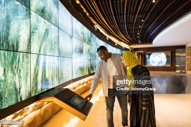 tourists using technology in at-turaif visitor’s centre - couple school stockfoto's en -beelden