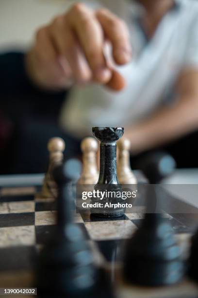 unrecognizable man moving chess piece with checkmate move aisle matte - ajedrez fotografías e imágenes de stock
