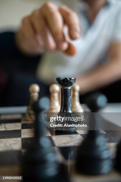 unrecognizable man moving chess piece with checkmate move aisle matte - conflict minerals stock pictures, royalty-free photos & images