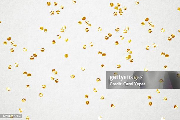 golden confetti in white bright background - gold confetti stock-fotos und bilder