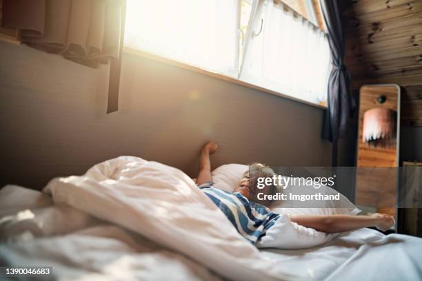 cute little boy waking up in the morning after sleeping well - morning bed stretch stock pictures, royalty-free photos & images