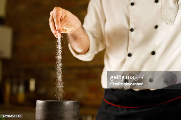 close up of a chef adding salt into his recipe. - adicionar sal imagens e fotografias de stock