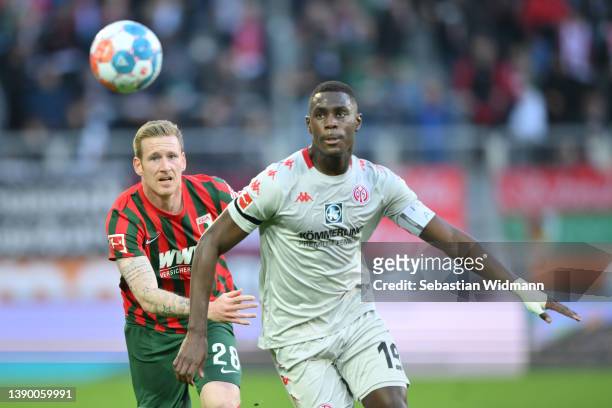 Andre Hahn of FC Augsburg and Moussa Niakhate of 1. FSV Mainz 05 eye the ball during the Bundesliga match between FC Augsburg and 1. FSV Mainz 05 at...