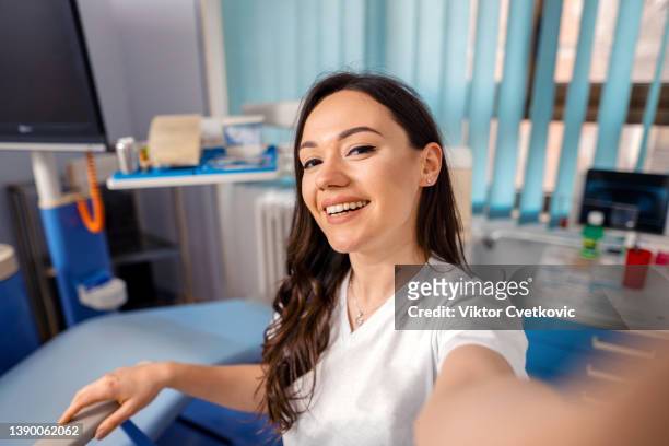 beautiful female dentist taking selfies in her office - dental office bildbanksfoton och bilder