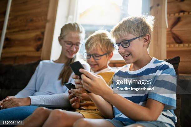 kids playing with modern smartphones - 10 11 jaar stockfoto's en -beelden